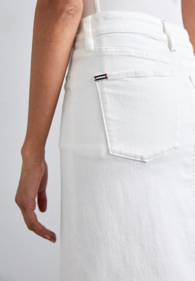 Falda de mezclilla blanca de talle alto, con un bolsillo trasero y costuras en contraste en rojo, azul marino y blanco. Textura suave.