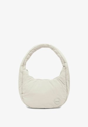 Svetlo béžová čalúnená kabelka s zaoblenou rukoväťou a malou okrúhlou nášivkou s logom v dolnej pravej časti, izolovaná na bielom pozadí.