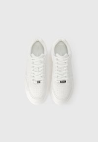 Λευκά αθλητικά παπούτσια με λείο δερμάτινο επάνω μέρος, περίτεχνη διακόσμηση, επίπεδα κορδόνια, επενδεδυμένος γιακά και ένα μικρό μεταλλικό λογότυπο στην γλώσσα.