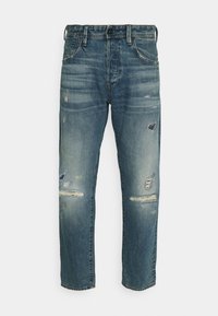 Dżinsy z denimu w spranym niebieskim kolorze o luźnym kroju, z przetarciami, postrzępionymi krawędziami i tradycyjnym pięciokieszeniowym fasonem.