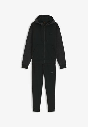 Sweat à capuche zippé noir pour homme avec manches gris foncé, associé à un pantalon de jogging noir assorti, tous deux arborant des logos BOSS discrets.