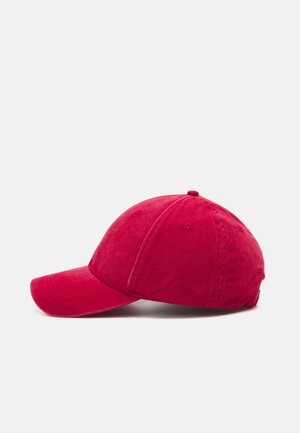 Casquette de baseball en coton rouge montrant une vue latérale avec une visière courbée et des panneaux cousus sur un fond clair uni.