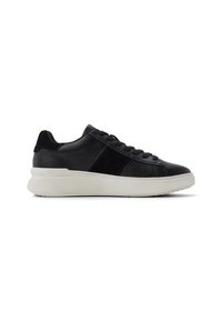 Sneaker in pelle nera con dettagli in suede, caratterizzata da una superficie testurizzata, lacci piatti e una suola bianca spessa. Vista laterale.