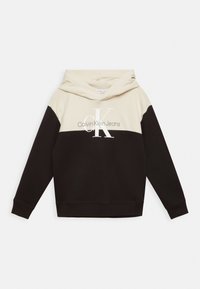 Felpa con cappuccio caratterizzata da una parte superiore crema e una parte inferiore nera, con il logo "Calvin Klein Jeans" in bianco sul petto. Materiale morbido.