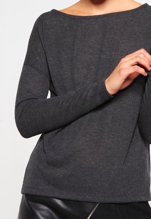 Haut à manches longues gris foncé avec un décolleté large et des manches ajustées. Le tissu semble doux et léger, légèrement texturé.