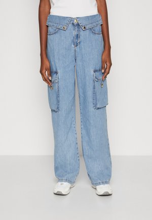 Pantaloni cargo in denim azzurro chiaro con vita alta, gambe larghe e ampie tasche laterali con zip. Completati da una chiusura con bottone e patta.
