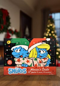 Calendario dell'Avvento a tema Puffi con 24 porte. Presenta personaggi blu in abbigliamento festivo, accenti rossi e verdi, e un motivo a stelle luminose.