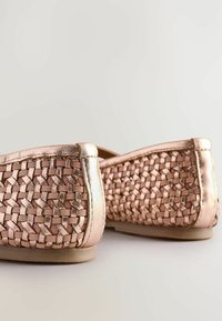 Ballerine in rose gold metalliche intrecciate con un motivo testurizzato e rifiniture lisce. Profilo basso con punta arrotondata e suole morbide.
