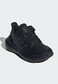 Schwarze Sport Sneaker aus synthetischem Leder mit strukturiertem Obermaterial, Gummisohle, Schnürung vorne und einem Klettverschluss sowie einem Design mit drei Streifen.