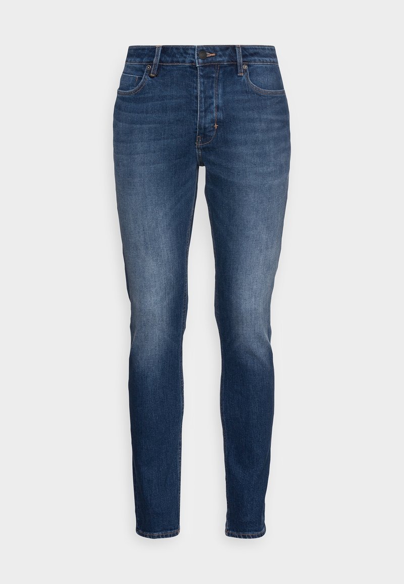 Mörkblå slim-fit jeans med frontknapp och dragkedja, klassisk femfickdesign och subtil blekning vid låren och knäna.
