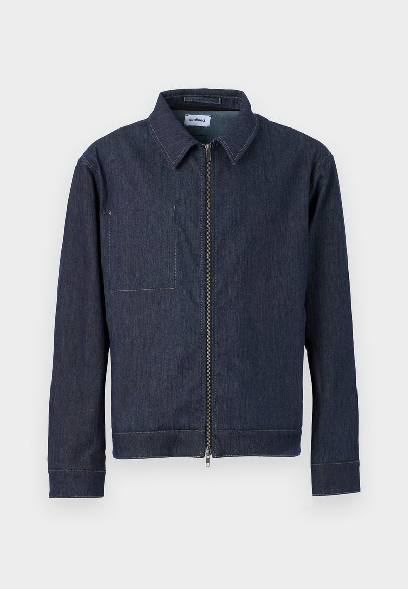 Veste en denim bleu foncé avec une fermeture éclair sur le devant, un col pointu, une poche poitrine à gauche et des accents brodés le long des poignets et de l'ourlet.