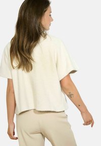 Cotton-blend, short-sleeved top in off-white with a herringbone pattern, featuring a relaxed fit and a hem that curves slightly at the back.