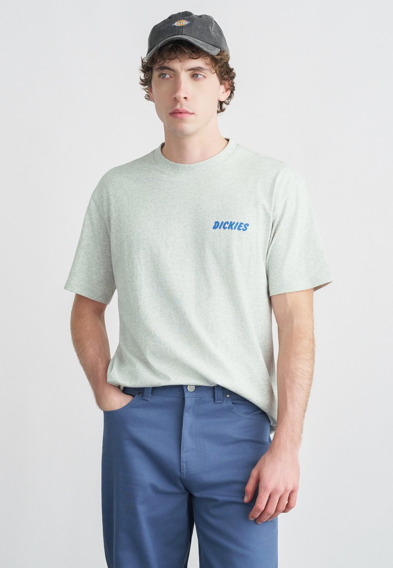 Γκρι κοντομάνικο μπλουζάκι με μπλε λογότυπο "DICKIES", σε συνδυασμό με μπλε παντελόνι· απαλό ύφασμα με άνετη εφαρμογή και στρογγυλή λαιμόκοψη.