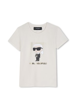 Koszulka w kolorze kremowym z rysunkową postacią w czarnych okularach przeciwsłonecznych i garniturze, z tekstem "KARL LAGERFELD" poniżej złotymi literami.