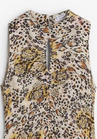 Top sin mangas de estampado de leopardo en beige, con acentos en morado y naranja. Textura ligeramente arrugada con un detalle de ojal en la parte posterior.