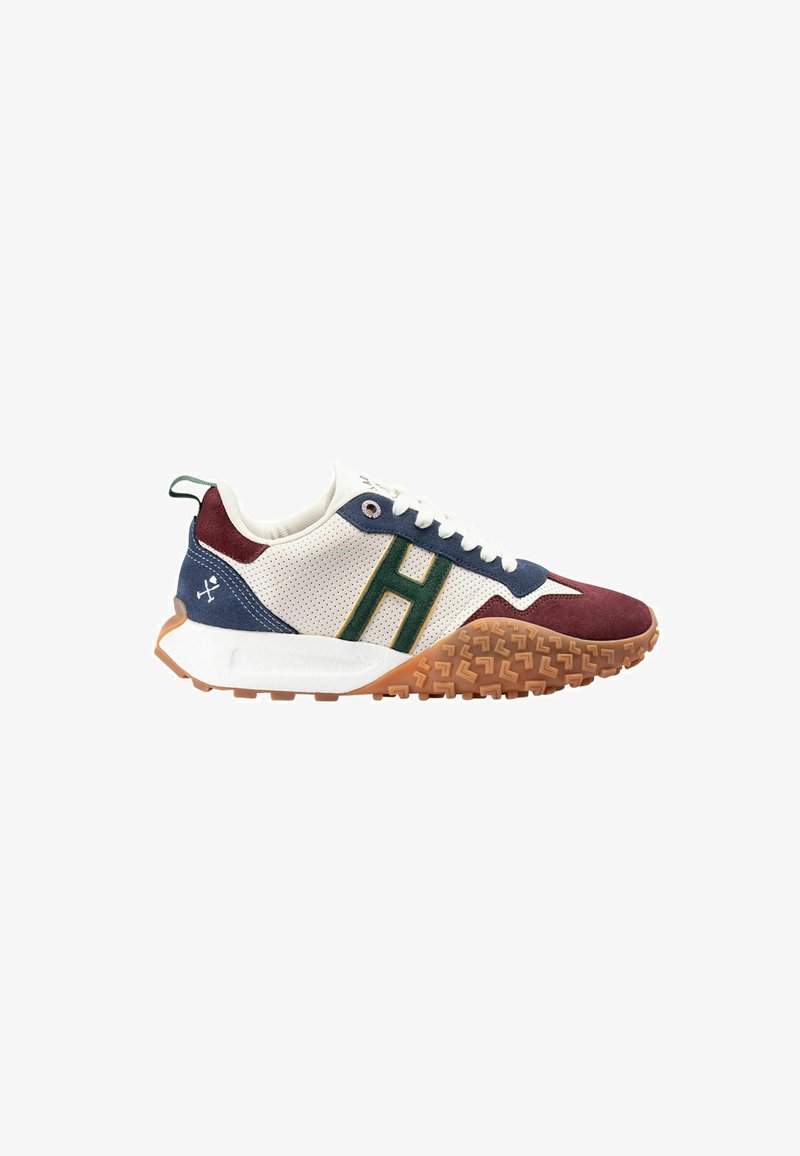 Zapatilla con parte superior de malla blanca, acentos de gamuza en azul marino y burdeos, logo "H" verde y suela de goma texturizada color goma.