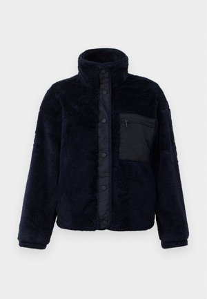 Marineblaue Fleecejacke mit hohem Kragen, Druckknöpfen und strukturiertem Finish. Verfügt über eine schwarze, mit Reißverschluss verschlossene Tasche auf der linken Brust.