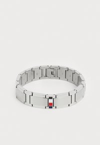 Metalarmbånd med sammenkoblede lenker, med en polert og børstet sølvfinish. Små røde, hvite og blå detaljer på låsen.