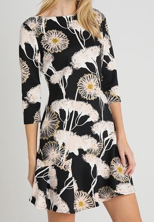 Robe noire avec un motif floral composé de fleurs roses et blanches, manches trois-quarts et une jupe évasée.