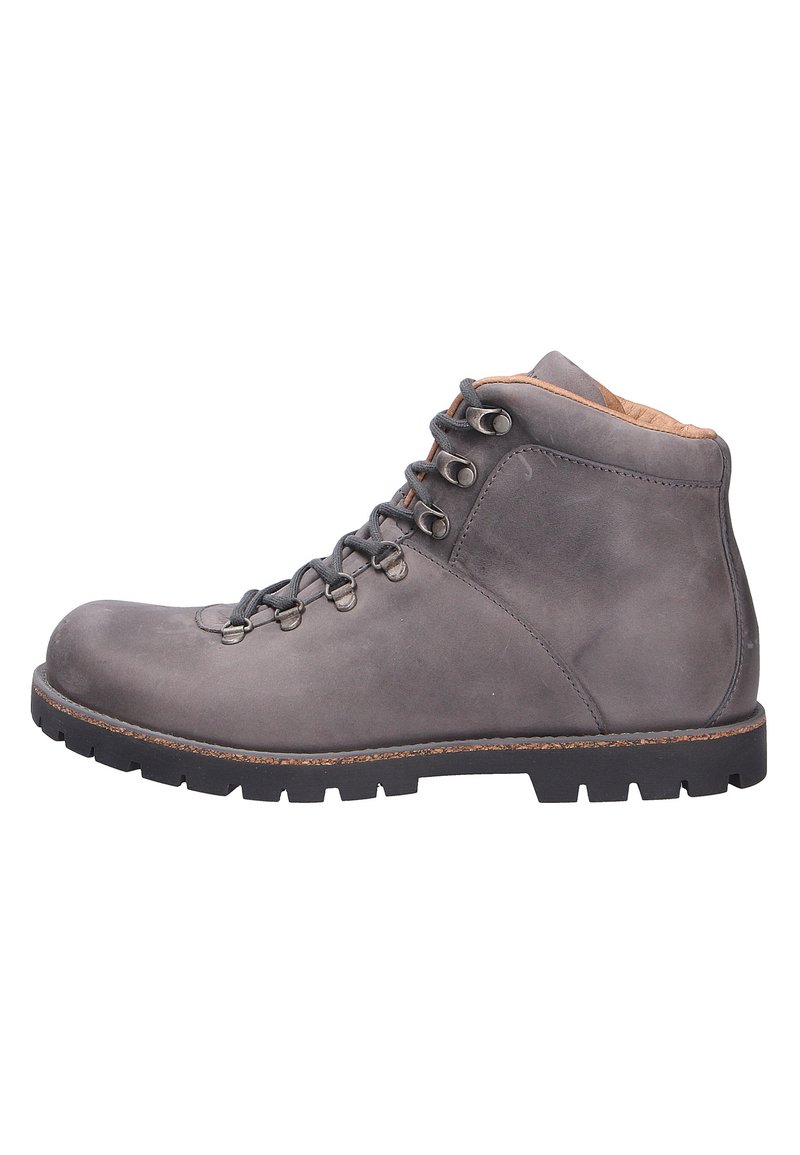 Botte de randonnée en cuir gris avec une pointe arrondie, sept oeillets, lacets marron et une semelle en caoutchouc noir robuste. Texture lisse et couture minimale.