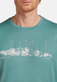 Camiseta de manga corta color verde azulado hecha de una tela texturizada, que presenta un gráfico de una montaña blanca con marcadores de altitud y el texto "Mont Blanc - 4808m."