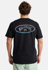 Sort bomulds T-shirt med et flerfarvet "Billabong" logo i ovalt design på ryggen. Kortærmet og med rund hals.