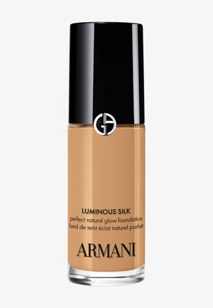 Armani Luminous Silk -meikkivoidepullo mustalla korkilla, beigen värisellä nesteellä ja Giorgio Armanin logolla läpinäkyvässä lasipakkauksessa.