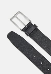 Ceinture en cuir noir avec une surface texturée, dotée d'une boucle rectangulaire en argent et de plusieurs trous d'ajustement le long de la sangle.
