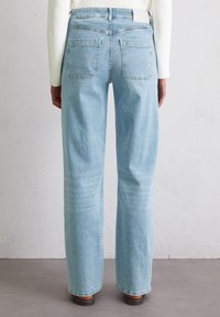 Lichtblauwe denim jeans met een ontspannen pasvorm. Voorzien van twee achterzakken en een recht model. Zichtbare stikseldetails en rafelige zoom.