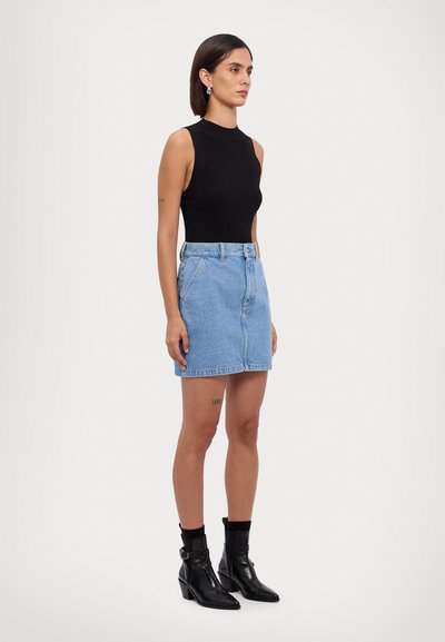 Črni rebrasti brezrokavnik, svetlo modra denim mini krilo s sprednjimi gumbi in zankami za pas, črne gležnarske škornje z ostrim nosom in blokom. 