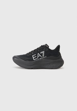 Zwarte sportieve sneaker met dikke zool, vetersluiting en wit "EA7 Emporio Armani" logo aan de zijkant.