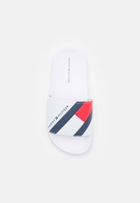 Infradito bianche con una fascia larga caratterizzata da strisce diagonali rosse e blu e il logo "TOMMY HILFIGER" sulla parte superiore. Texture liscia.