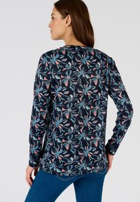 Maglietta a maniche lunghe con una base blu navy, caratterizzata da un motivo floreale in blu, rosa e verde. Tessuto liscio con scollo rotondo e vestibilità slim.