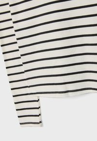 Langærmet top med sort-hvide vandrette striber, lavet af blød bomuld. Har en afrundet kant og kontraststing.