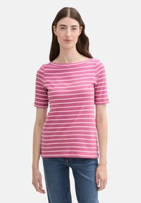 Pink and white striped short-sleeve shirt with a rounded neckline, made of soft material. Worn with blue jeans, light texture.
