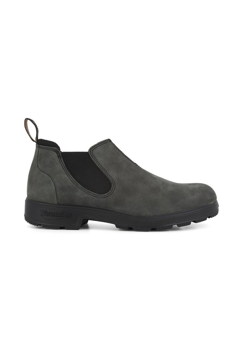 Botines de ante gris oscuro, tipo slip-on, que cuentan con paneles laterales elásticos y una suela de goma negra texturizada, además de una pestaña en el loop para facilitar su uso.