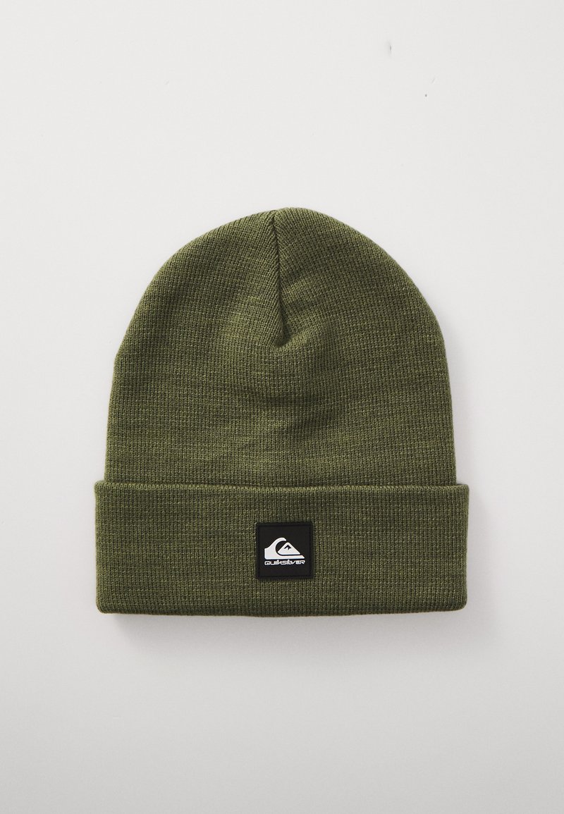 Olijfgroene gebreide beanie met een omgeslagen rand, voorzien van een zwart vierkant label met een wit logo aan de voorkant. Zachte textuur en een goede pasvorm.