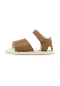 Sandal in pelle marrone con una larga fascia anteriore, aperto sul retro e chiusura regolabile in Velcro. Presenta una suola in gomma bianca texturizzata.