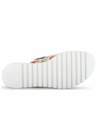 Biała gumowa podeszwa z poziomymi rowkami, z kwiatowym wzorem na górnej części. But ma okrągły kształt z podniesionym obcasem.