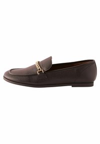 Smeđe kožne mokasine s teksturiranom površinom, ravnim potplatom i zlatnim lancem preko prednjeg dijela. Elegantan dizajn, minimalno šivanje.