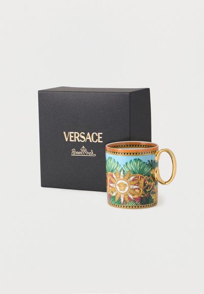 Διακοσμητικό κεραμικό φλιτζάνι με χρυσή λαβή, πράσινα και χρυσά περίτεχνα σχέδια, δίπλα σε μαύρο κουτί με την ετικέτα Versace Rosenthal σε χρυσά γράμματα.