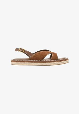 Hnědá semišová rovná sandála s překříženými pásky, nastavitelnou přezkou na kotníku a detailním pleteným vzorem na podrážce.