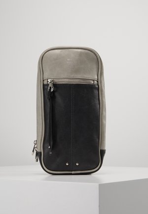 Rektangulær todelt sort og grå læderpung med lynlåslomme foran og sort lynlåstrækker, stående oprejst på en hvid overflade.