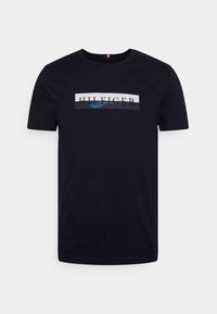 Męski czarny bawełniany t-shirt z centralnym nadrukiem zawierającym tekst "HILFIGER" w białych, niebieskich i szarych paskach. Klasyczny dekolt typu crew neck.
