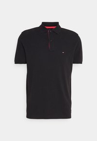 Schwarzes Poloshirt aus Baumwolle mit Kragen, Zwei-Knopf-Leiste, kurzen Ärmeln und einem roten Akzentstreifen in der Nähe des Kragens. Kleines Logo auf der linken Brust.
