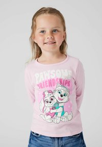 Világos rózsaszín, hosszú ujjú póló, amelyen kedves kutyák láthatók, a "Csodás Barátságok" felirattal, vastag fehér és rózsaszín betűkkel. Pamut anyag.