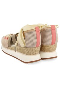 Baskets compensées en beige et rose avec un matériau en mesh, des lacets en ruban et une semelle intermédiaire en jute. Comprend une semelle en caoutchouc blanche et des accents texturés.