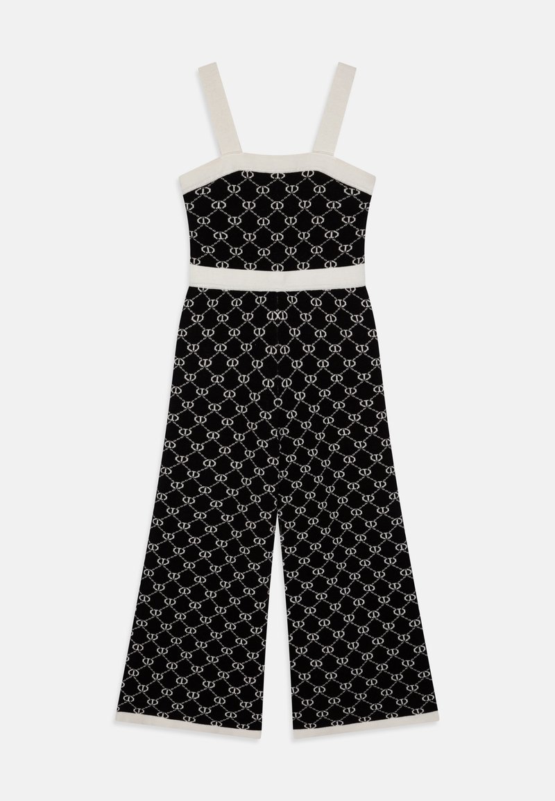 Svart jumpsuit med vitt geometriskt mönster, strukturerad kropp, vida ben och krämfärgade band och midja. Mjuk tygtextur.