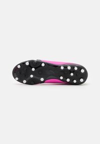 Scarpone da calcio con una tomaia di un vivace colore rosa, suola nera con tacchetti circolari e dettagli testurizzati per aderenza e flessibilità.