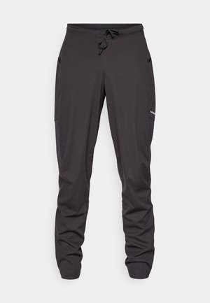 Zwarte sportieve broek met drawstring, zijzakken, licht gekreukt stof en een klein zichtbaar logo op de rechterdij.